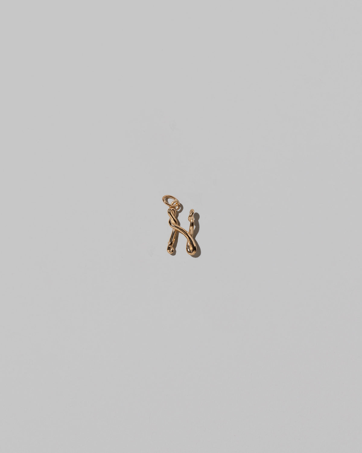 CRZM Mini Letter N set in solid gold on light color background.