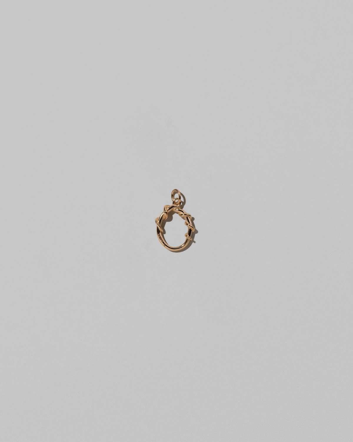 CRZM Mini Letter O set in solid gold on light color background.