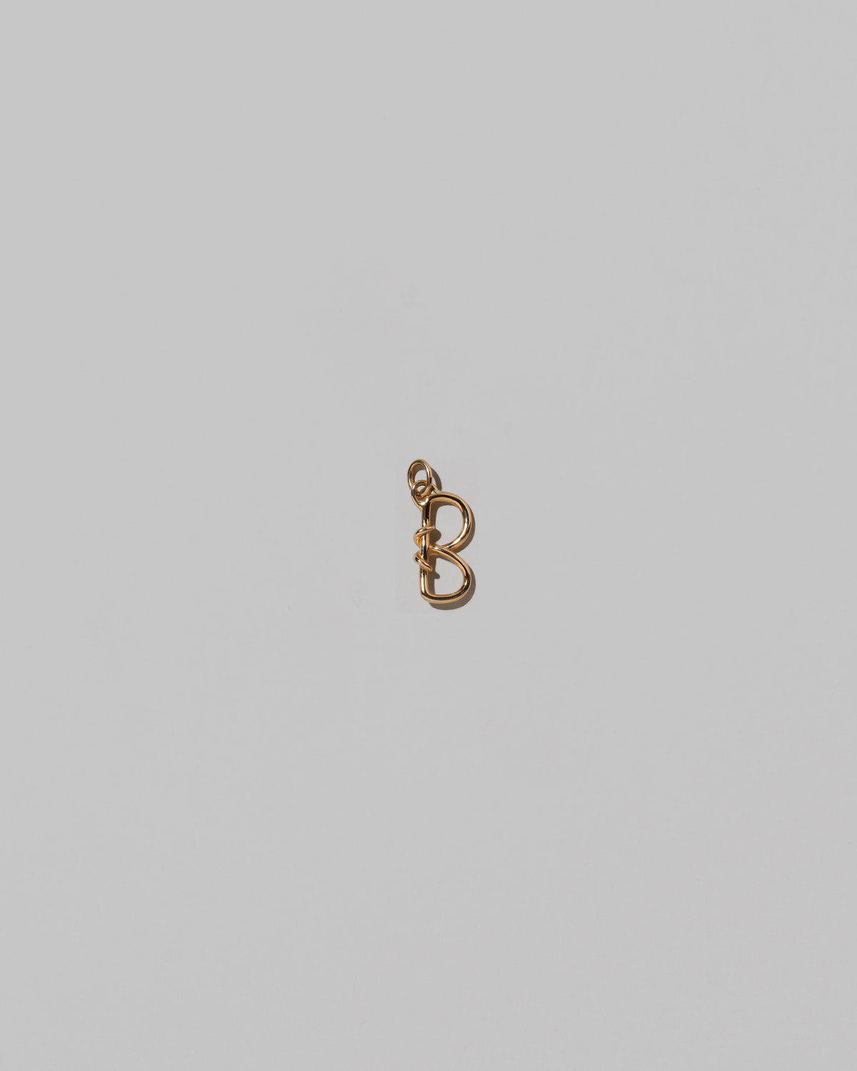 CRZM Mini Letter B set in solid gold on light color background.