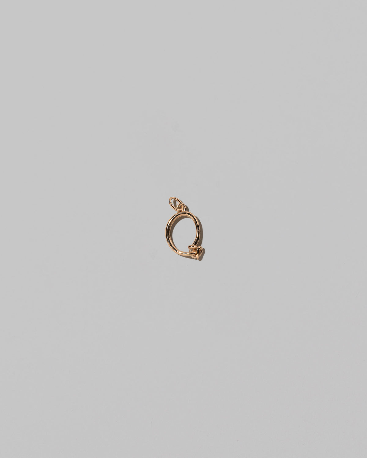 CRZM Mini Letter Q set in solid gold on light color background.