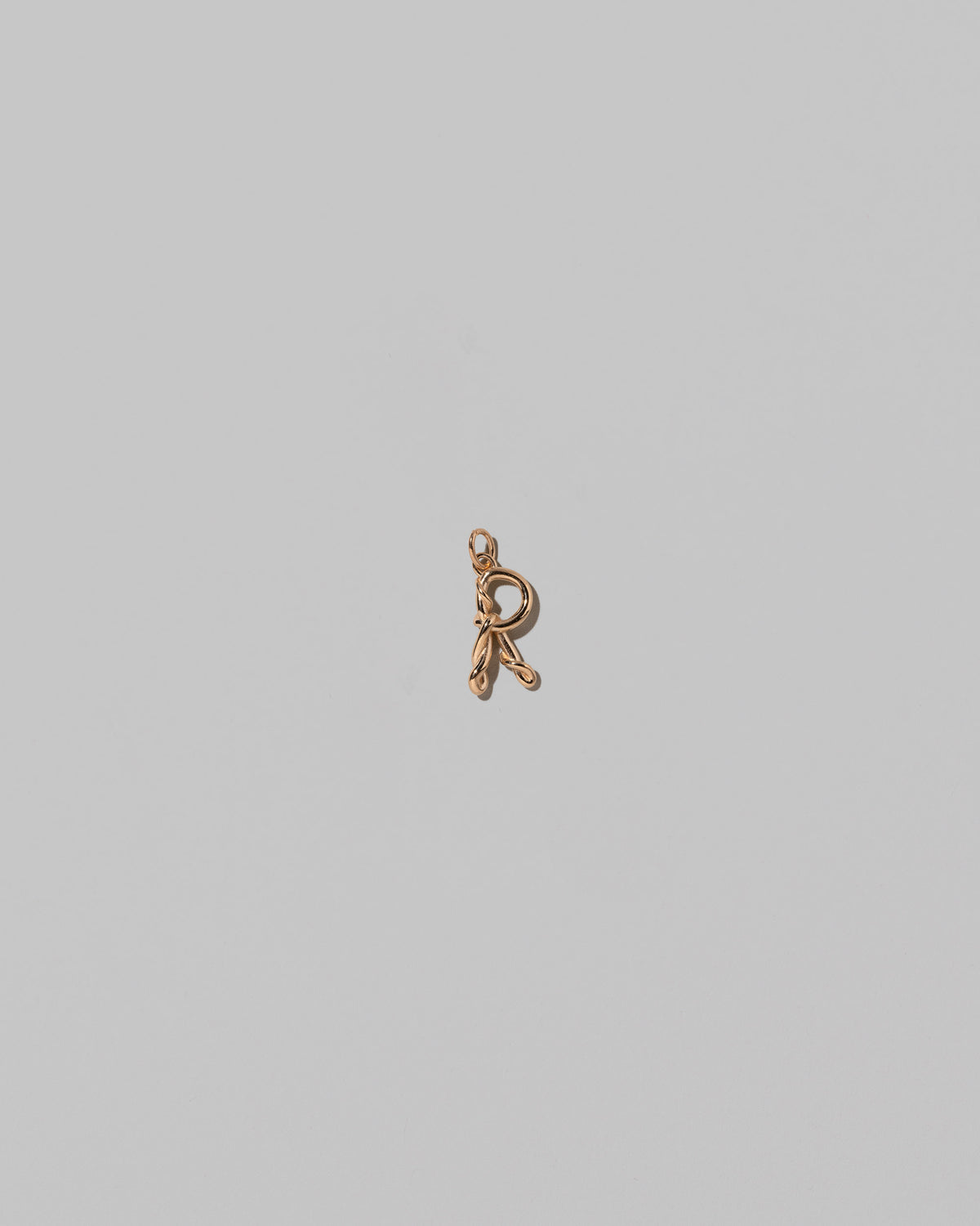 CRZM Mini Letter R set in solid gold on light color background.