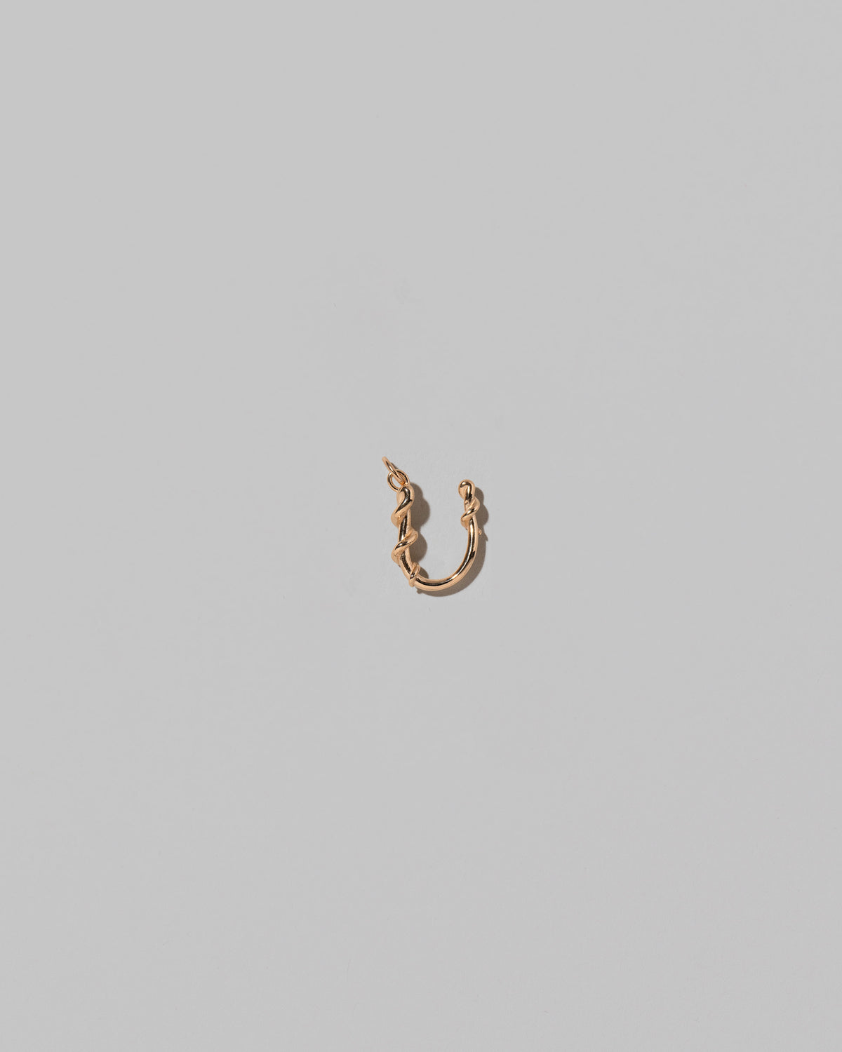 CRZM Mini Letter U set in solid gold on light color background.