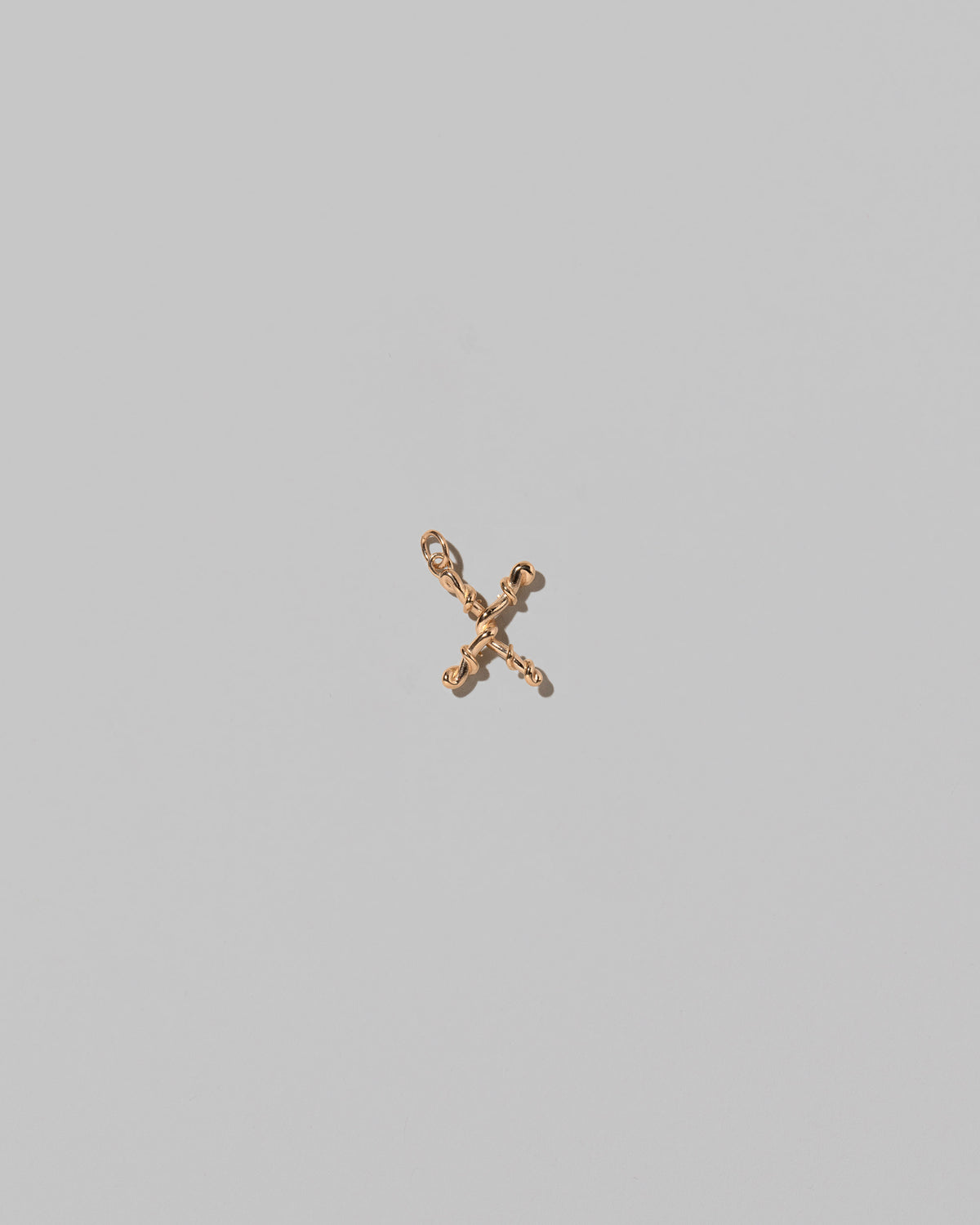 CRZM Mini Letter X set in solid gold on light color background.