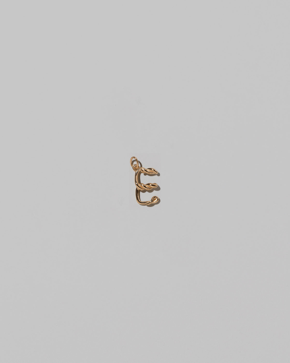 CRZM Mini Letter E set in solid gold on light color background.