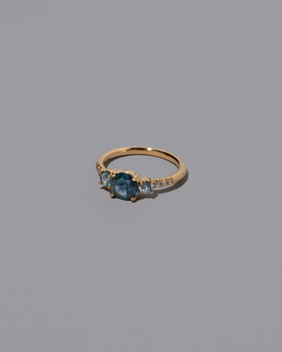 View from the side of the Sapphire Orion Ring on grey color background.