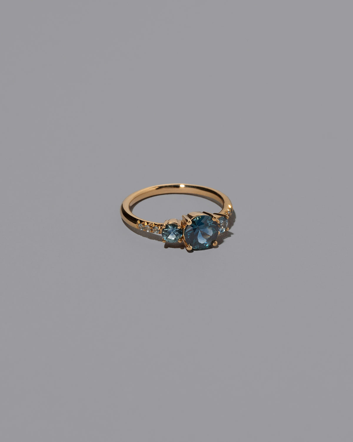 View from the side of the Sapphire Orion Ring on grey color background.