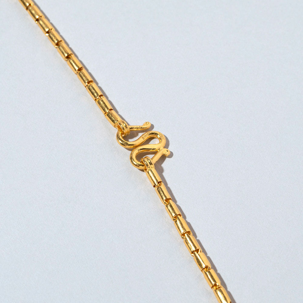 product_details::Closeup details of the Serpiente Chain Necklace on light color background.