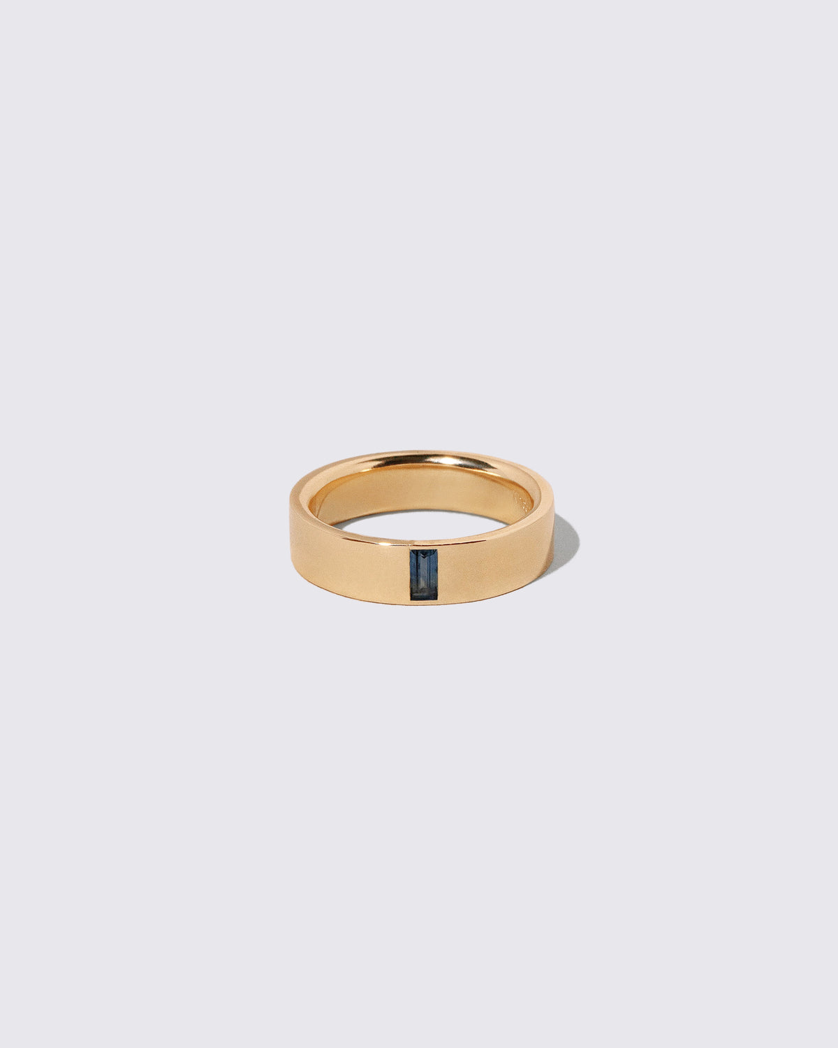 Gold Australian Bicolor Sapphire North South 5mm Baguette-Set Piet Band on light color background.