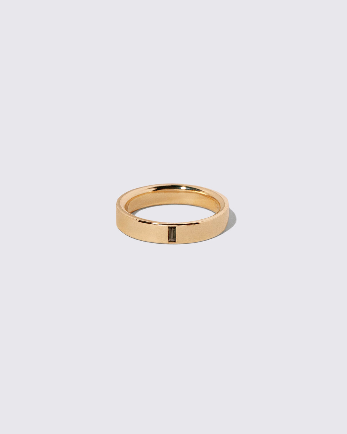 Gold Andalusite North South 4mm Baguette-Set Piet Band on light color background.
