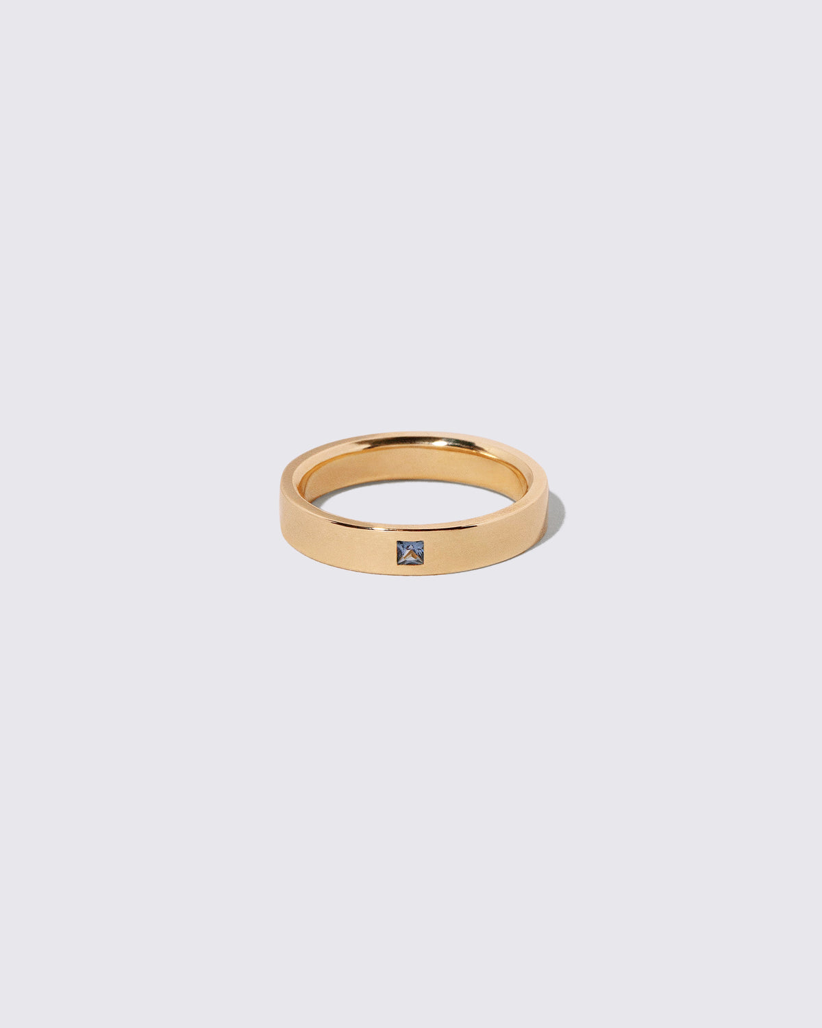 Gold Yogo Mine Cornflower Blue Sapphire 4mm Square Cut Piet Band on light color background.