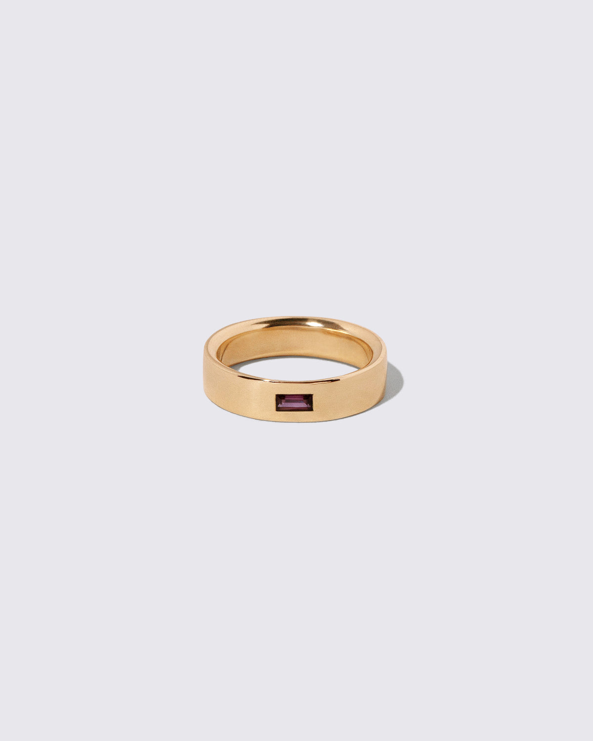 Gold Anthill Red Garnet East West 5mm Baguette-Set Piet Band on light color background.