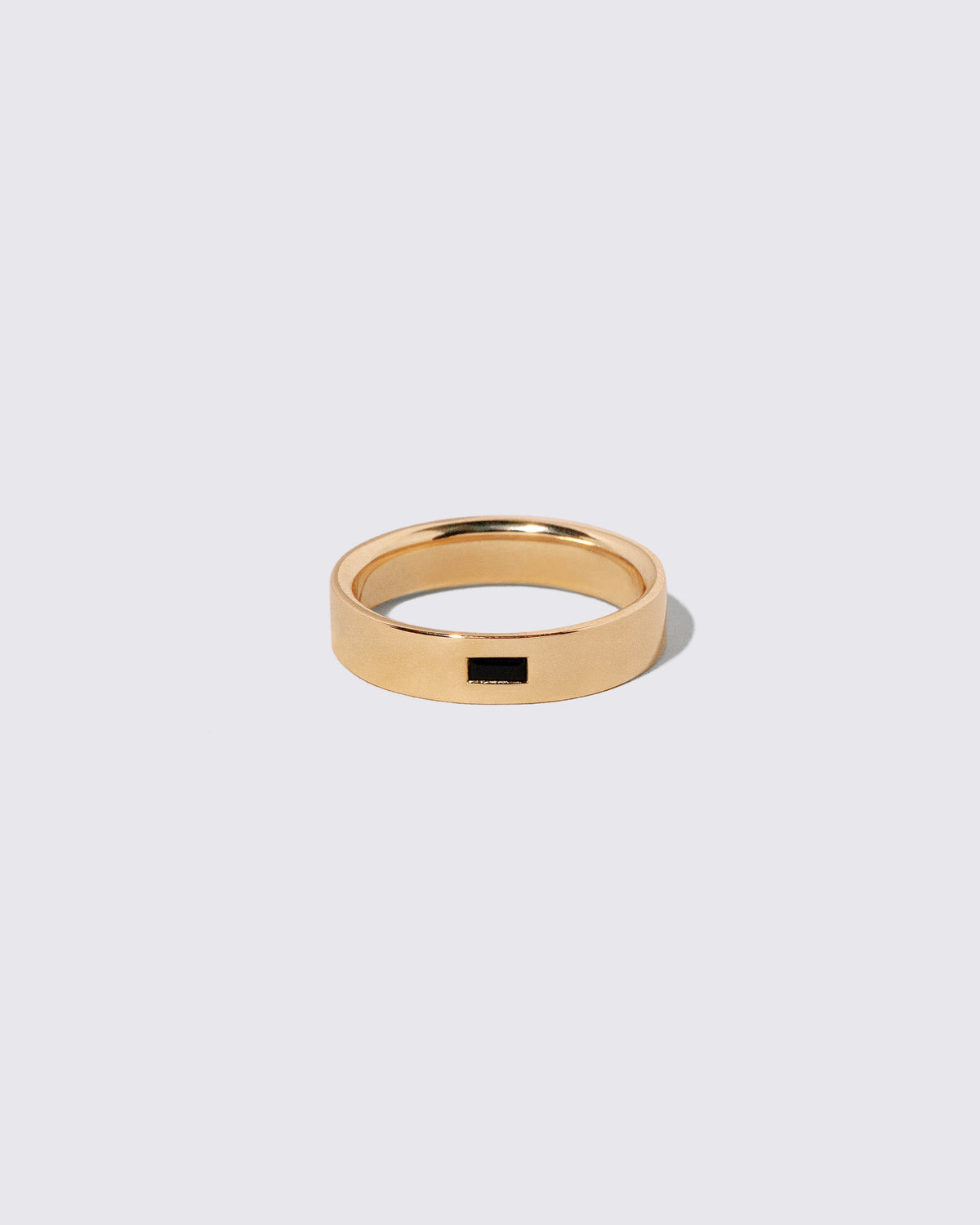 Gold Black Spinel East West 5mm Baguette-Set Piet Band on light color background.