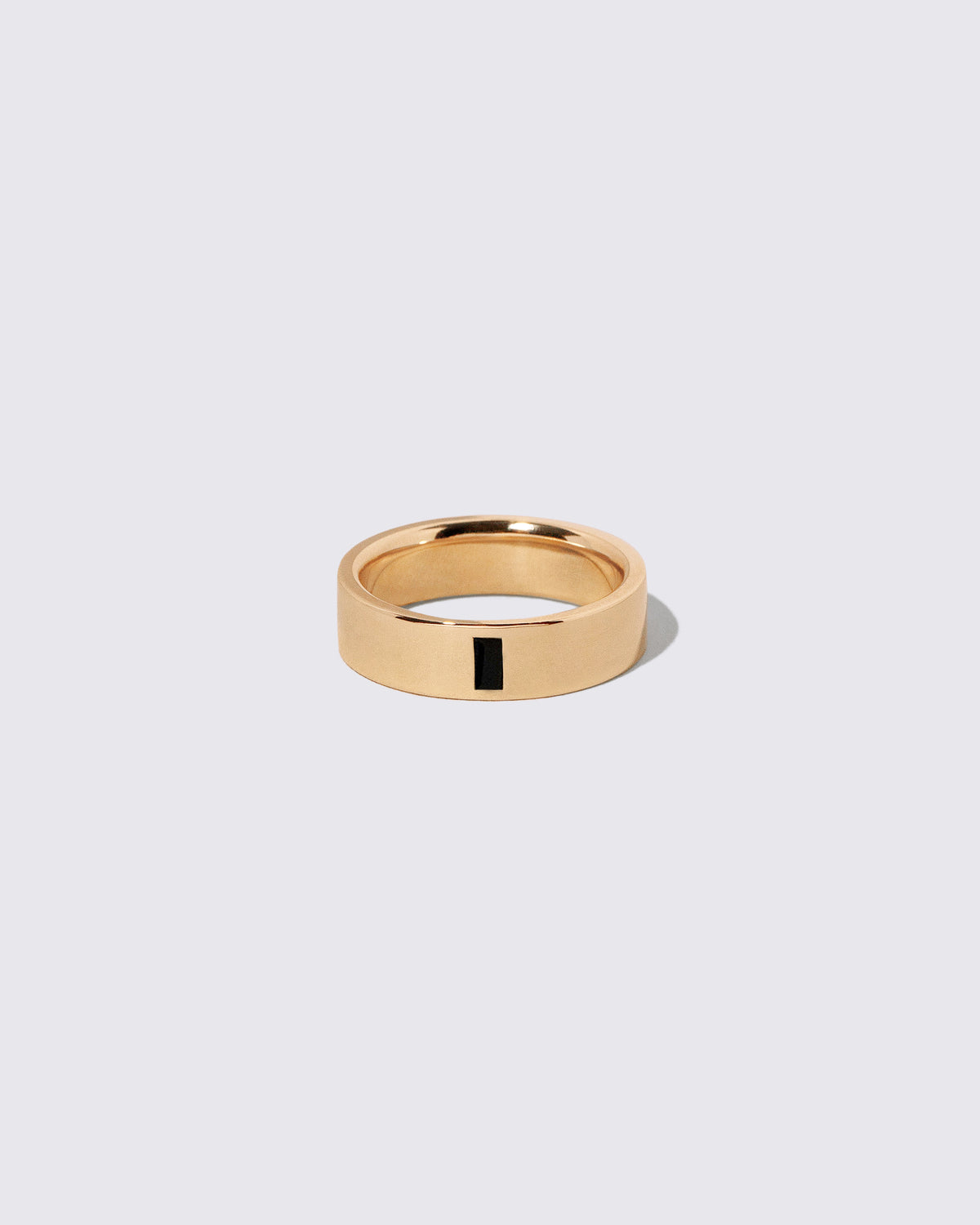 Gold Black Spinel North South 6mm Baguette-Set Piet Band on light color background.
