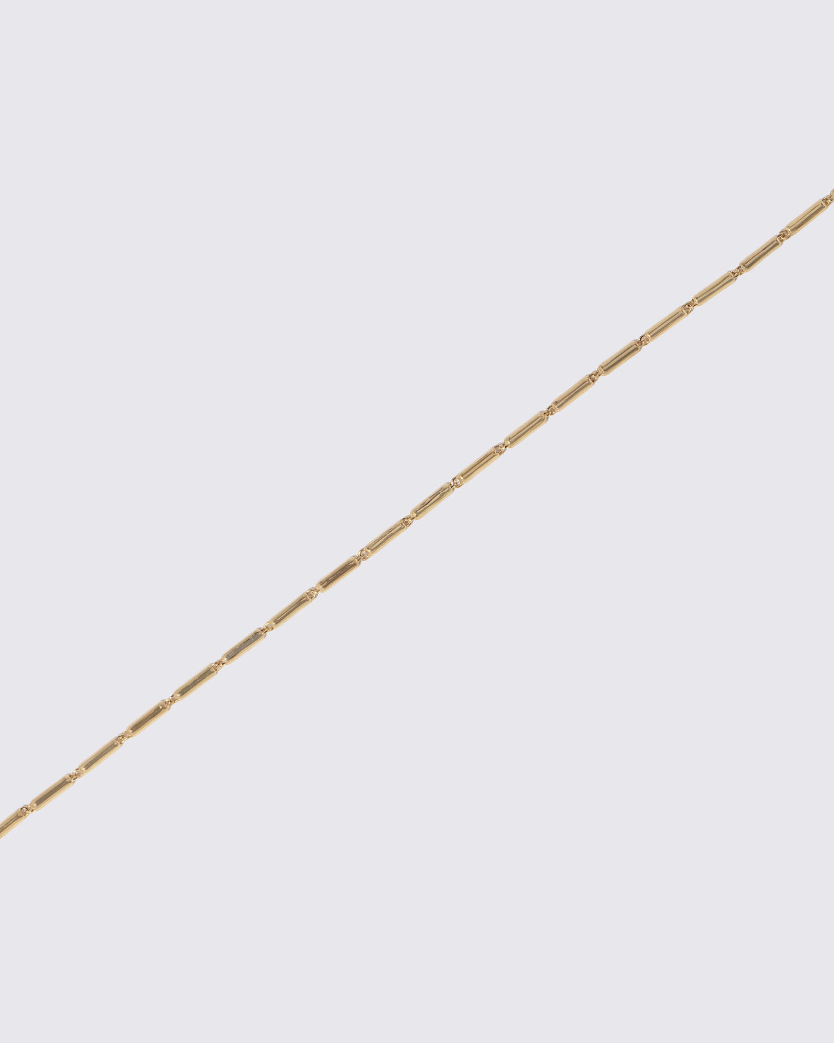 Closeup details of the Gold Butter Chain Bracelet on light color background.