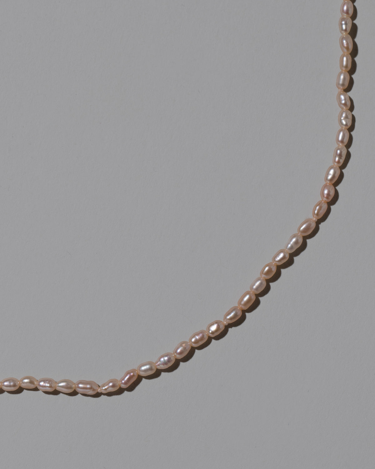 Closeup details of the Pink Oval Seed Pearl Bracelet on light color background.