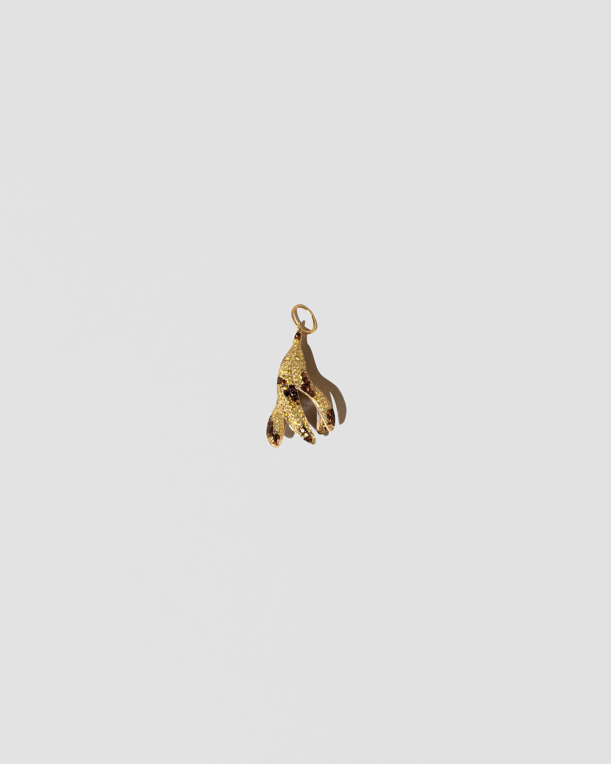 View from the back of the Bruised Banana Peel Charm on light color background.