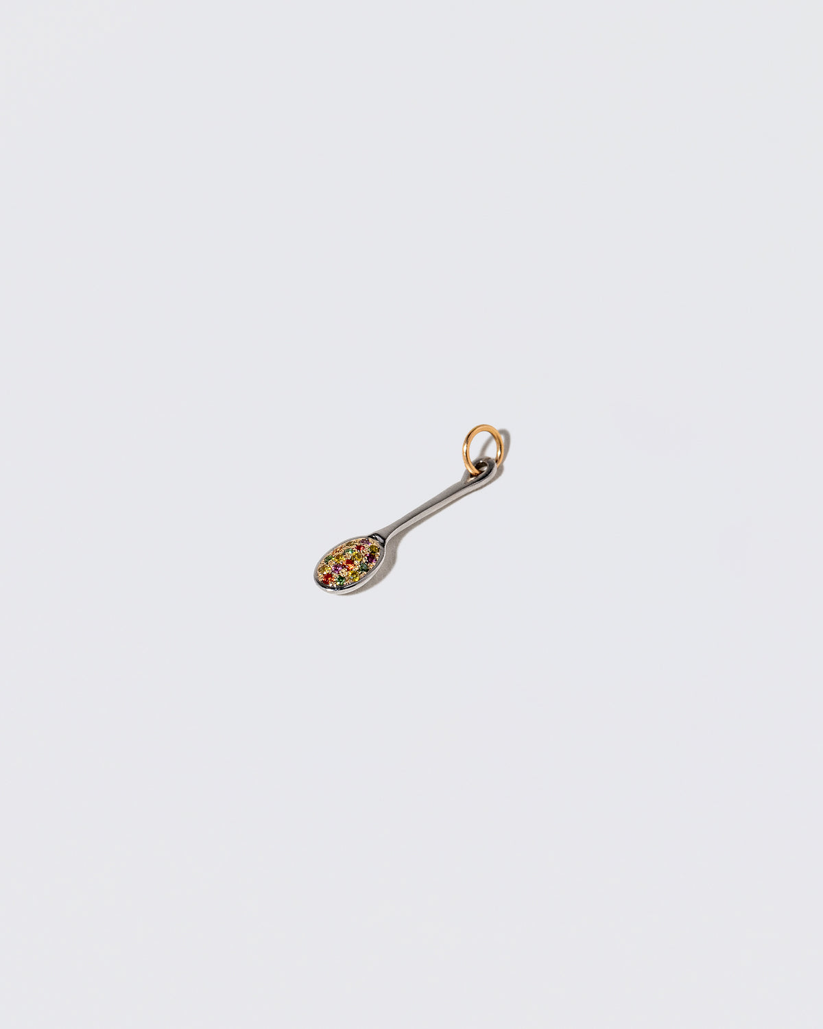 View from the side of the Cereal Spoon Charm on light color background.