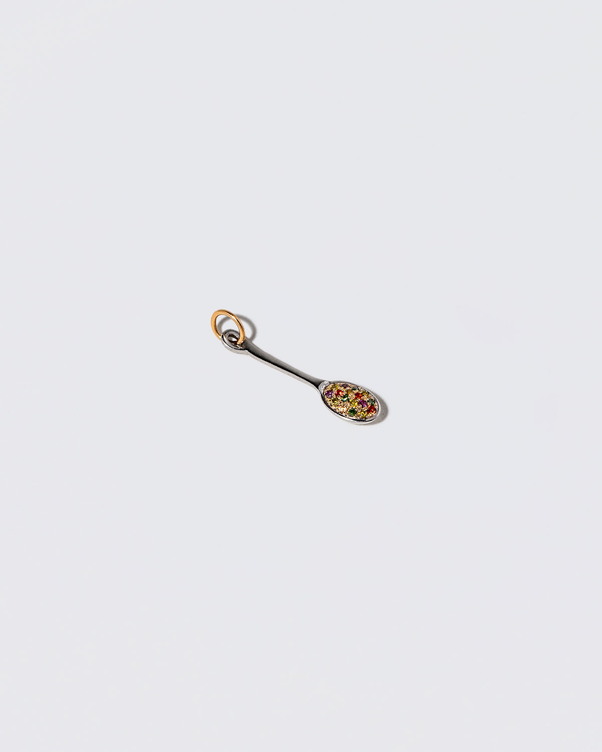 View from the side of the Cereal Spoon Charm on light color background.