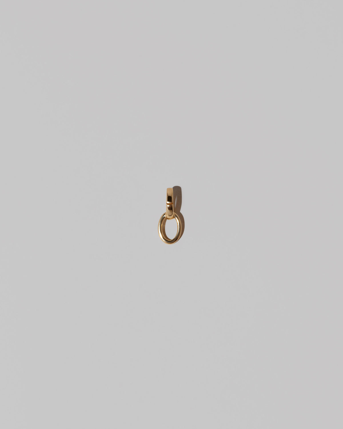 Two Gold Endless Clasp Charms on light color background.