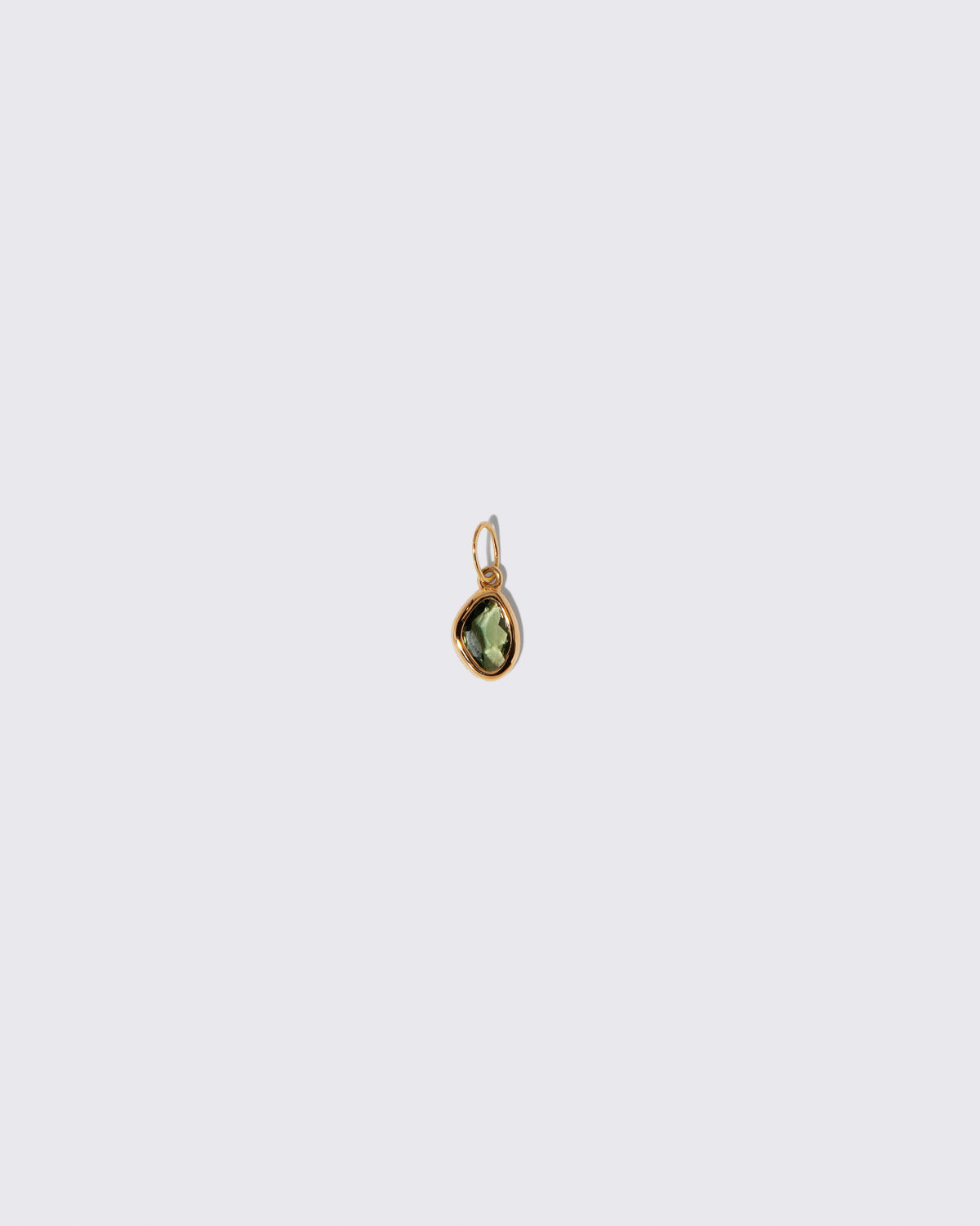 Green Sapphire Gusher Charm on light color background.