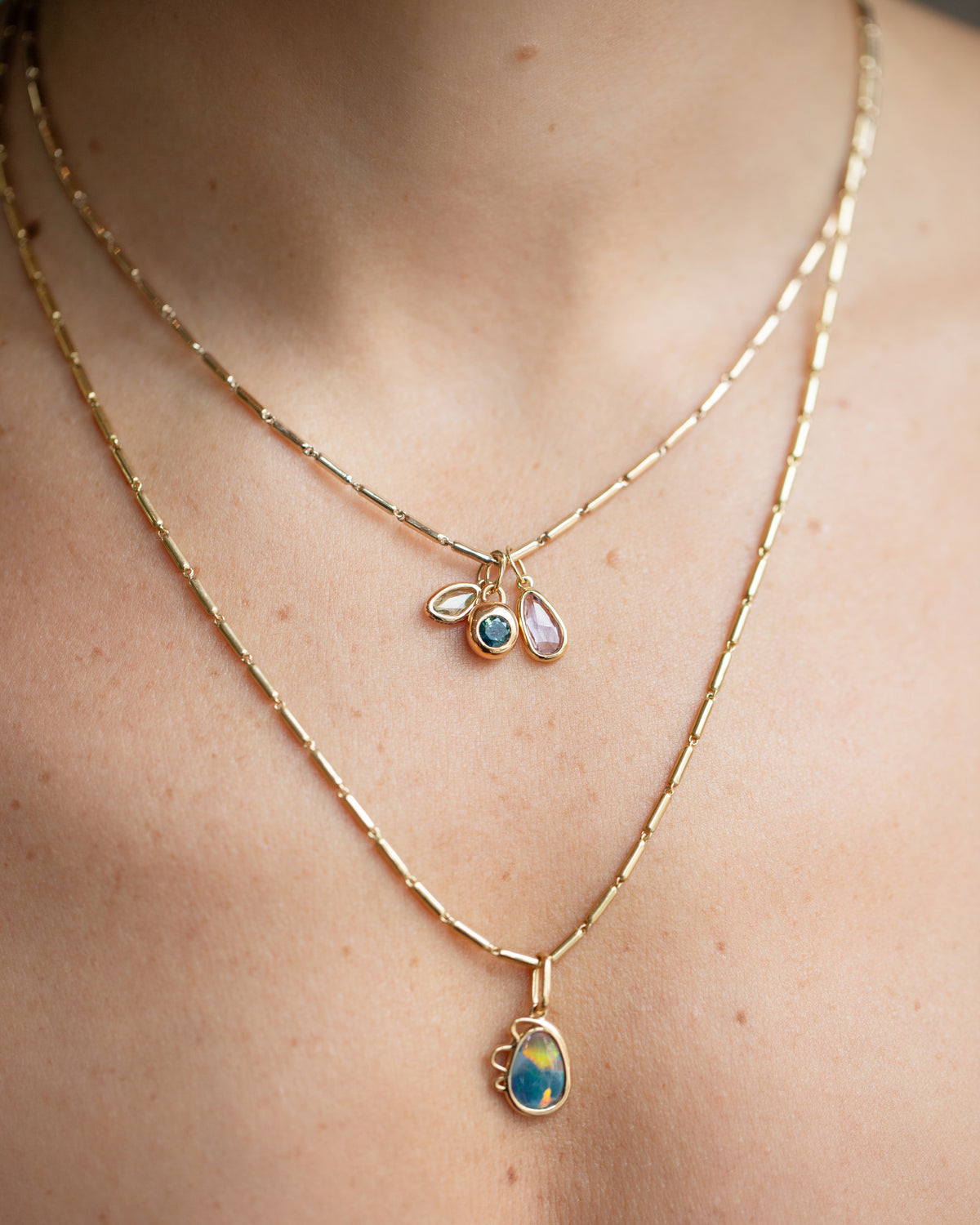 Harmony Pendant, Sapphire Birthstone Level Charm and Purple and Yellow Sapphire Gusher Charm with Gold Butter Chain Necklaces on model.