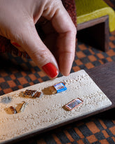 Styled image of the Instant Ramen Charm, with the Joint Charm, Dirty Martini Charm and Chocolate Bar Charm.