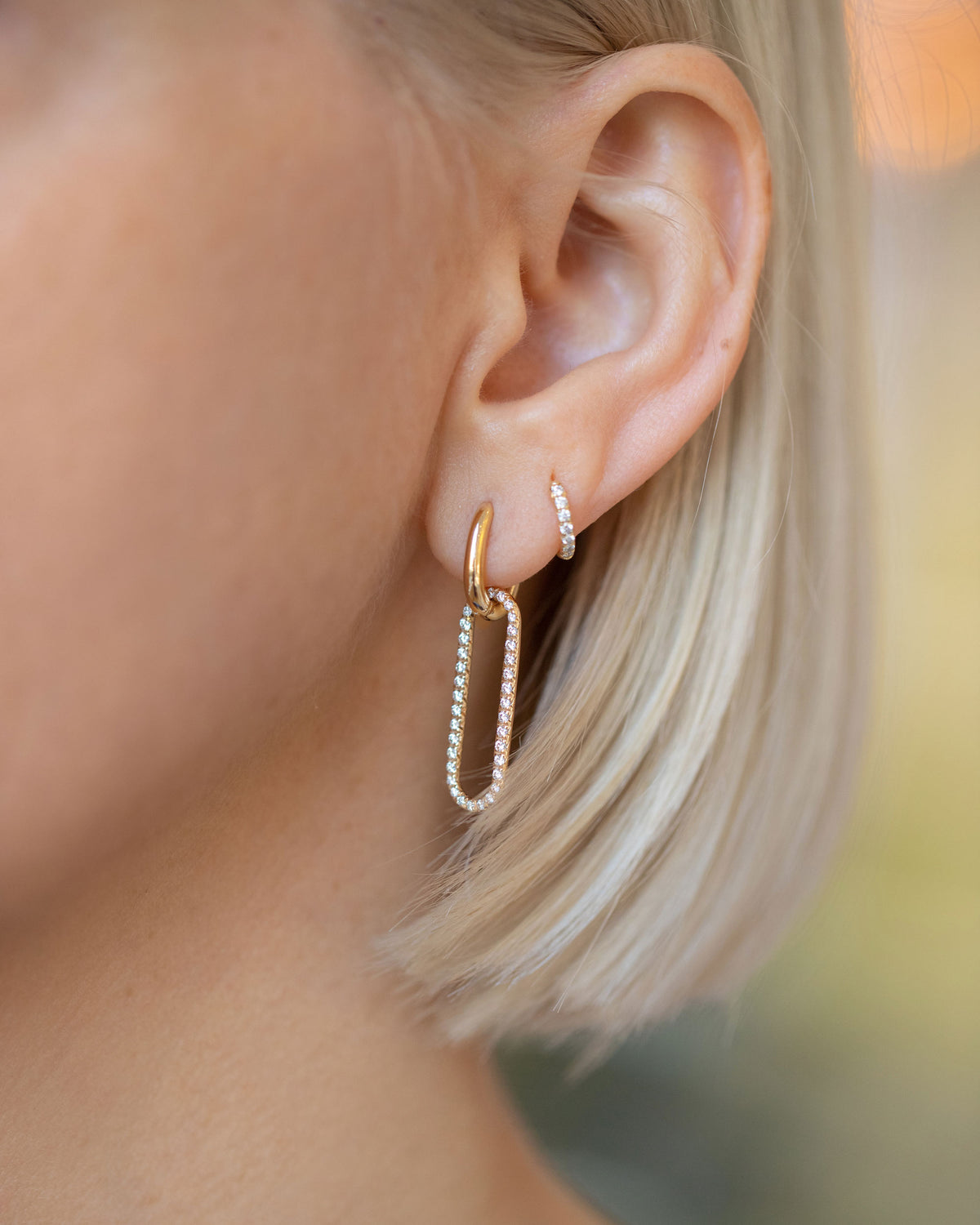 Huggie Gold Pavé Snack Hoop Earrings and Link Huggie Earring Single with Pavé Link Charm on model.