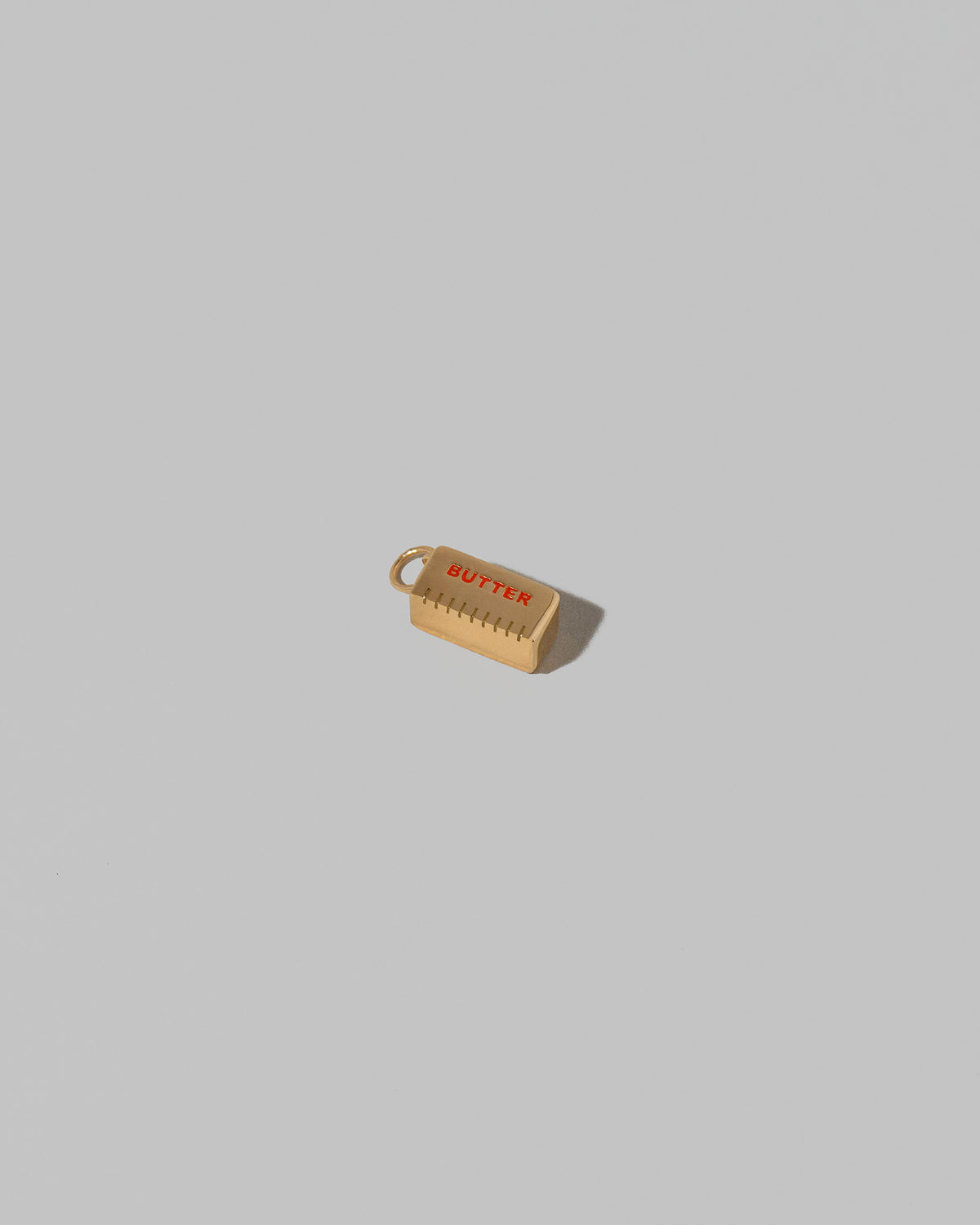 Stick of Unsalted Butter Charm on light color background.