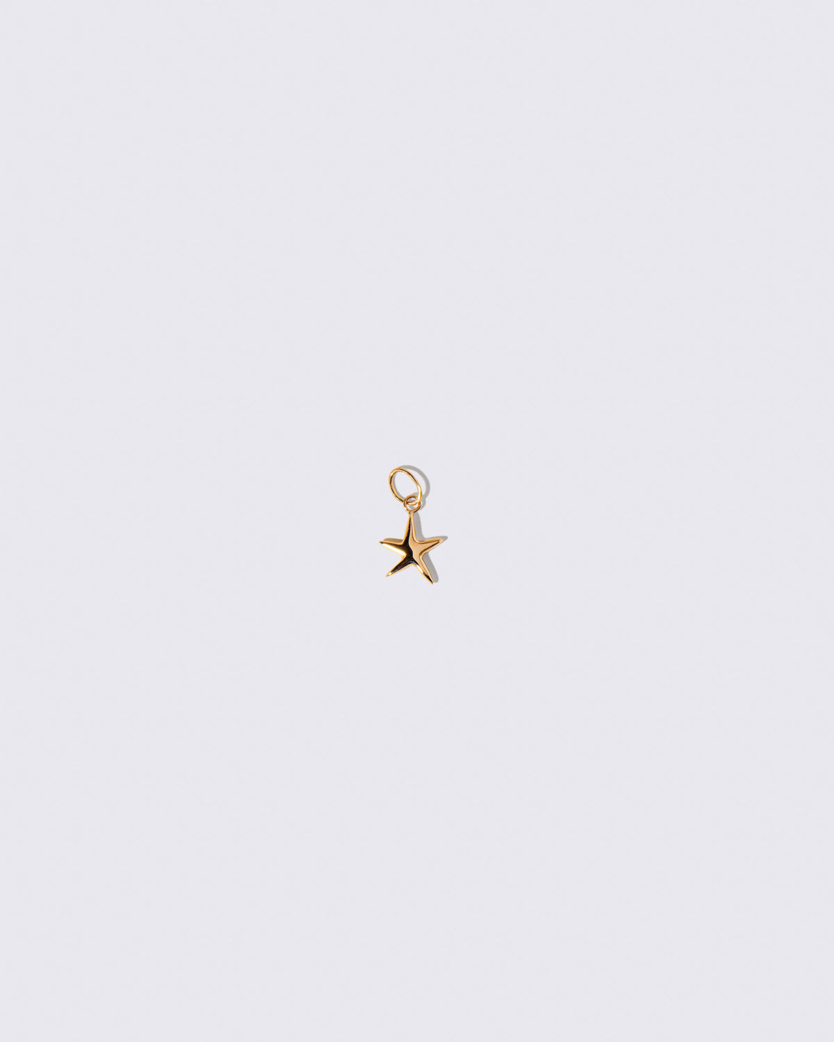 Gold Verve Five Point Star Charm on light color background.