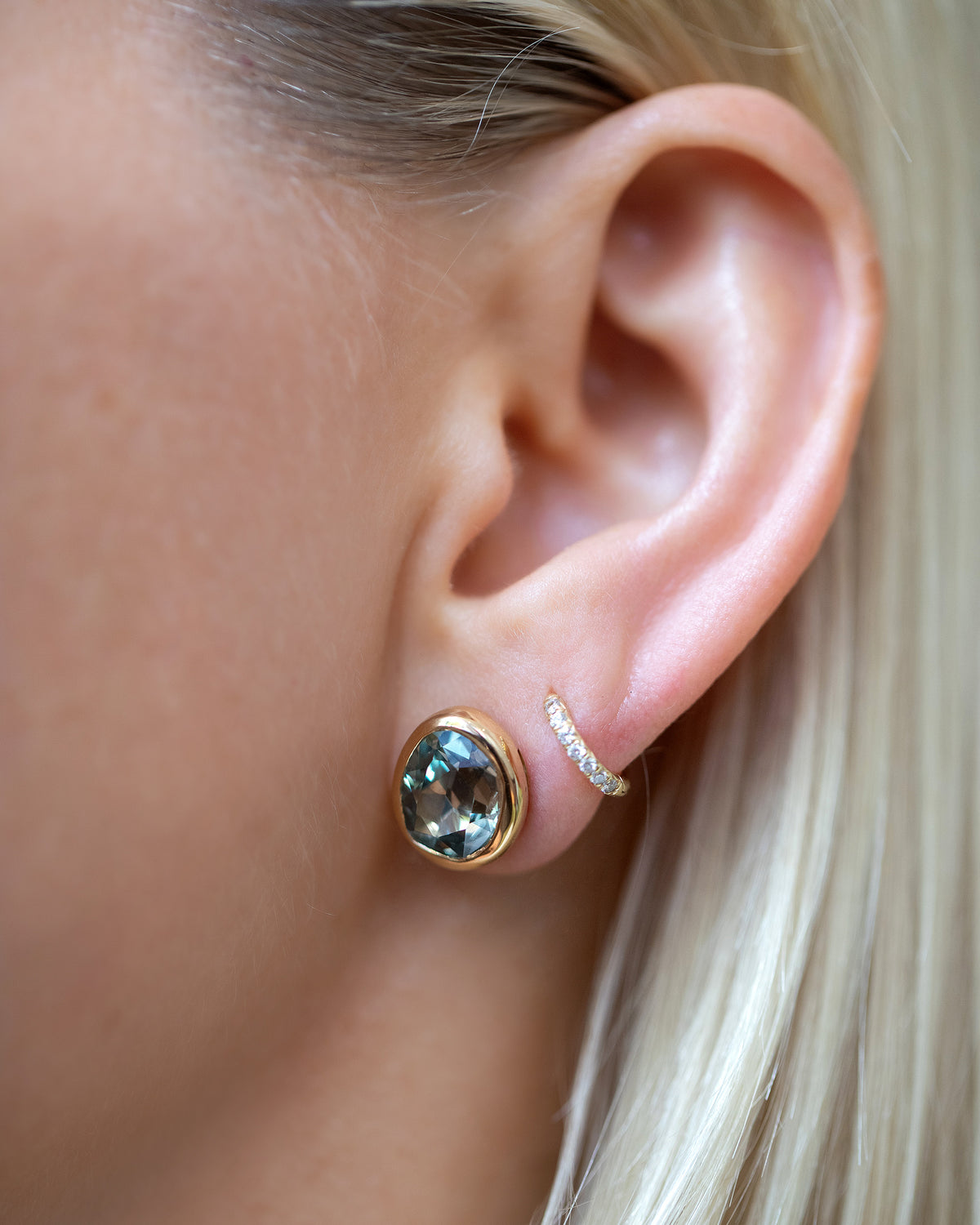 Juniper Stud Earrings styled with Huggie Gold Diamond Snack Hoop Earrings on model.