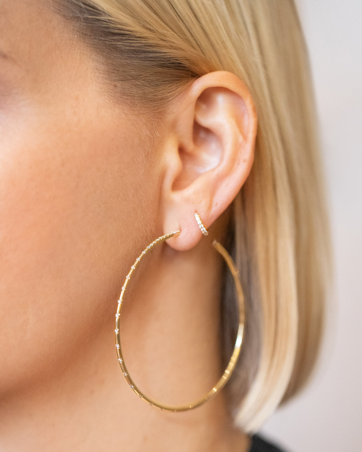 Large Pave Diamond Hoop Earrings and Huggie Gold Diamond Snack Hoop Earrings on model.