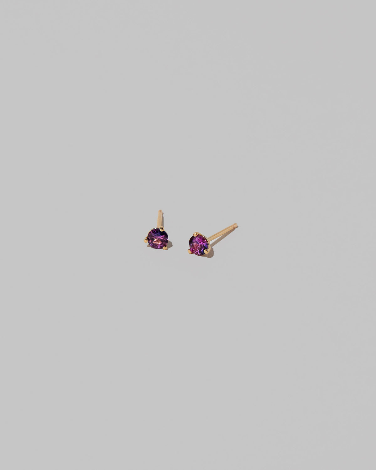Petite Bicolor Purple Sapphire Martini Stud Earrings on light color background.