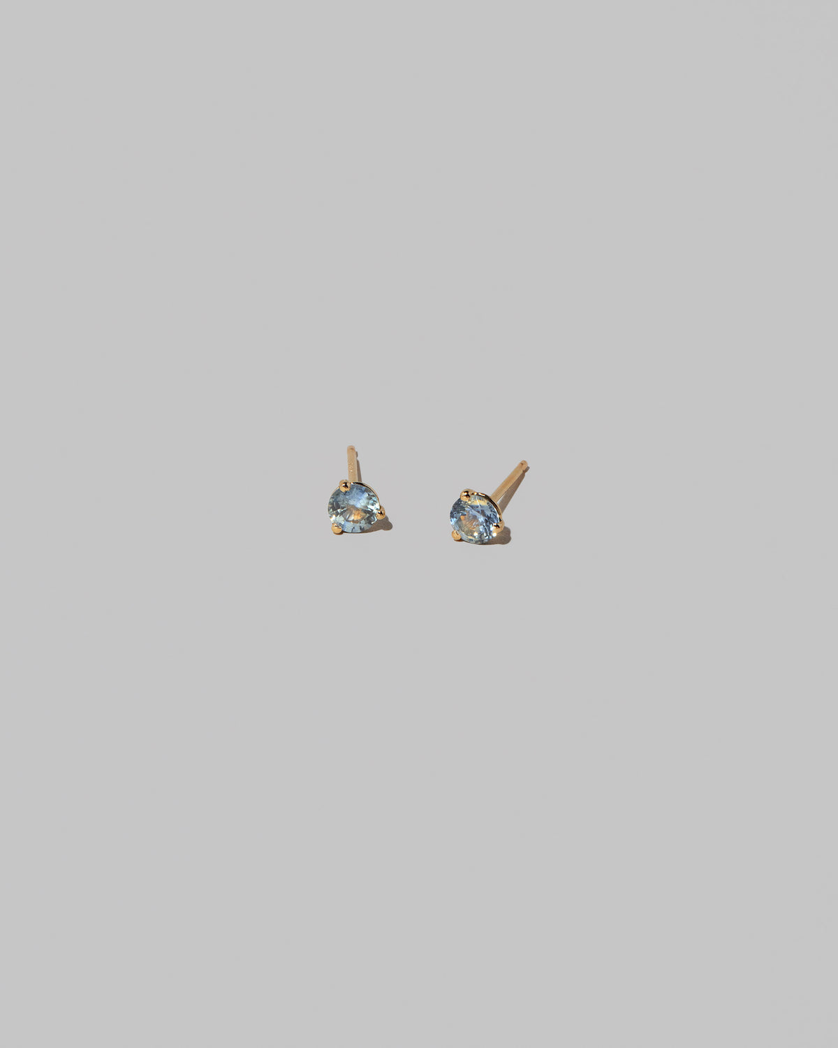Bicolor Blue & Yellow Sapphire Martini Stud Earrings on light color background.