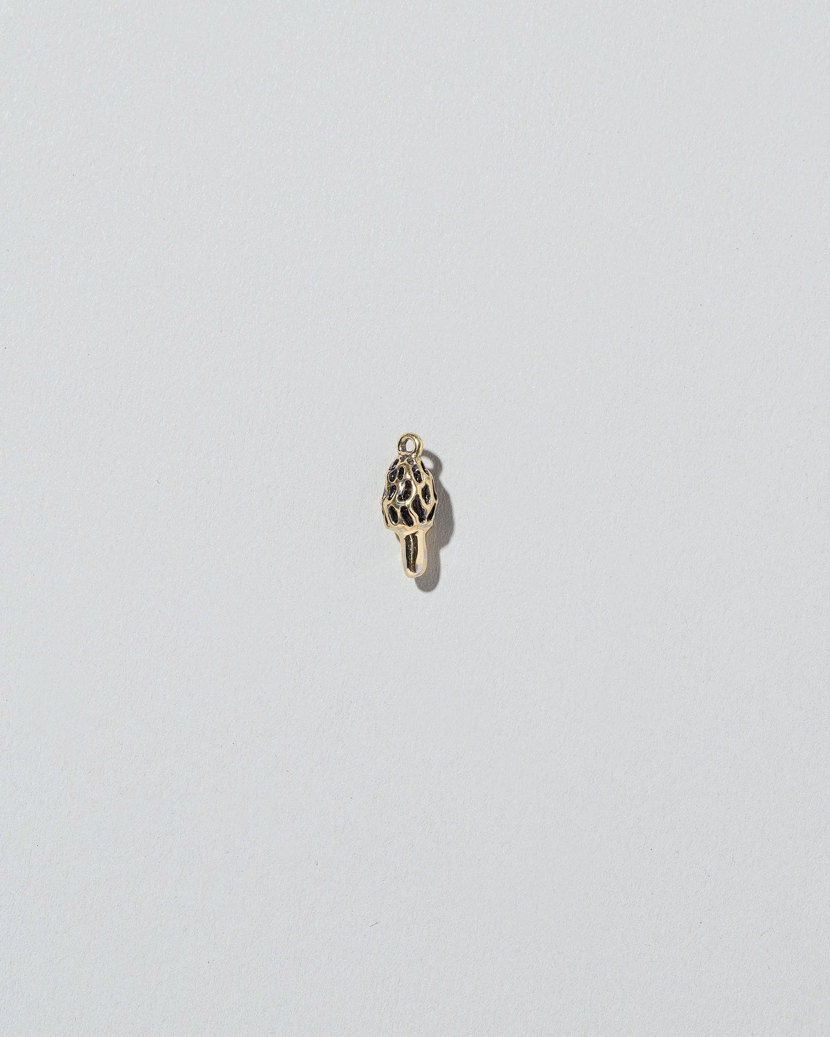 Morel Mushroom Charm on light color background.