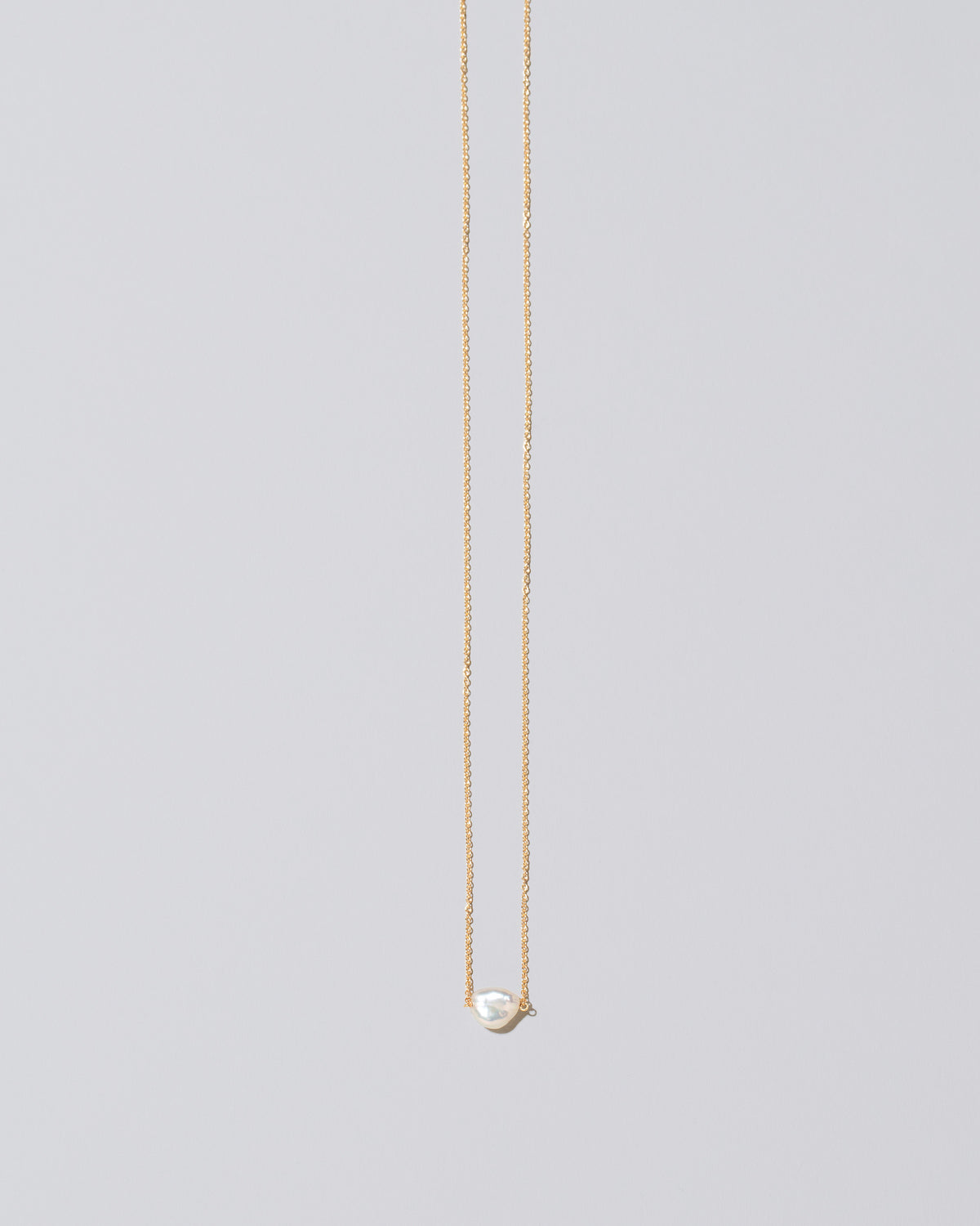 White Lagniappe Pearl Necklace on light color background.