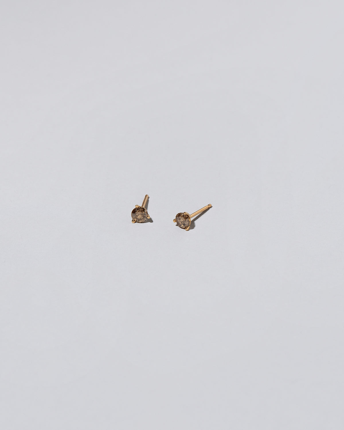Cognac Diamond Martini Stud Earrings on light color background.