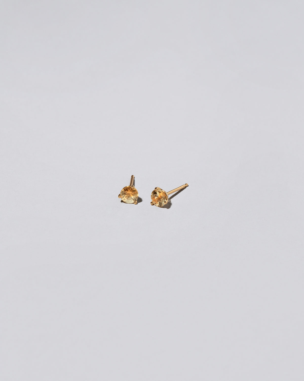 Kaleidoscope Yellow Sapphire Martini Stud Earrings on light color background.