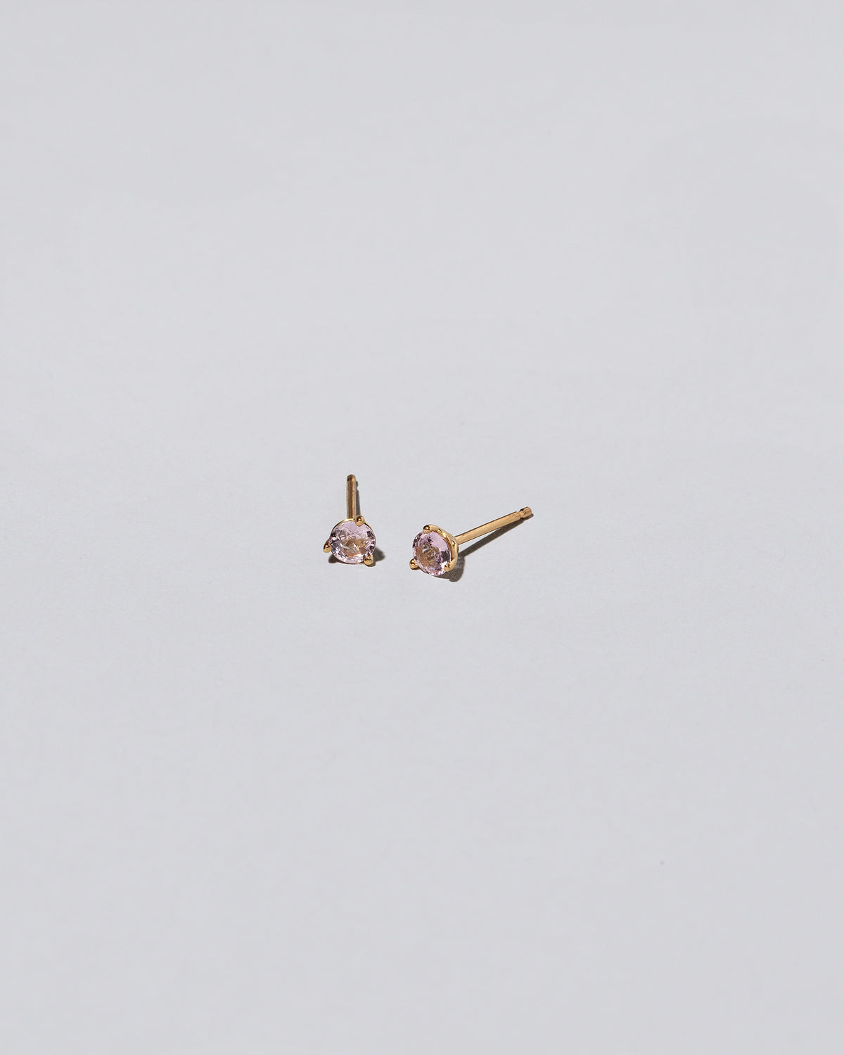 Light Pink Sapphire Martini Stud Earrings on light color background.