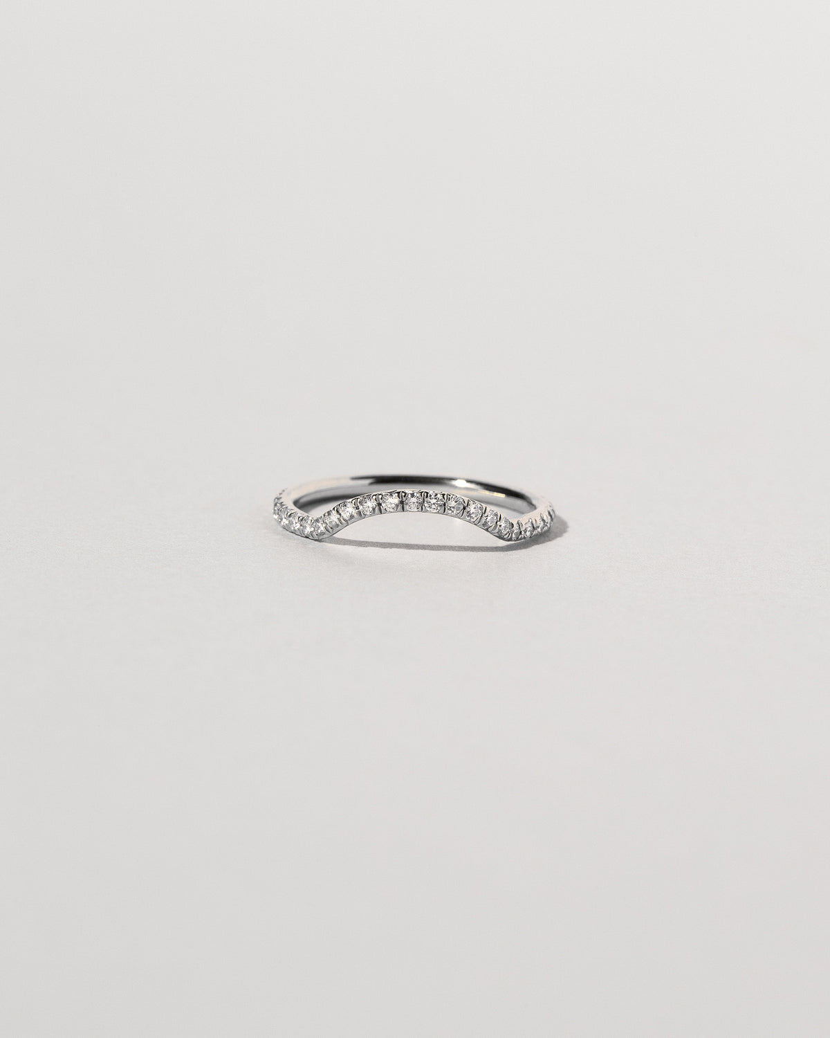 Platinum White Diamond Pavé Mini Curve Band on light color background.