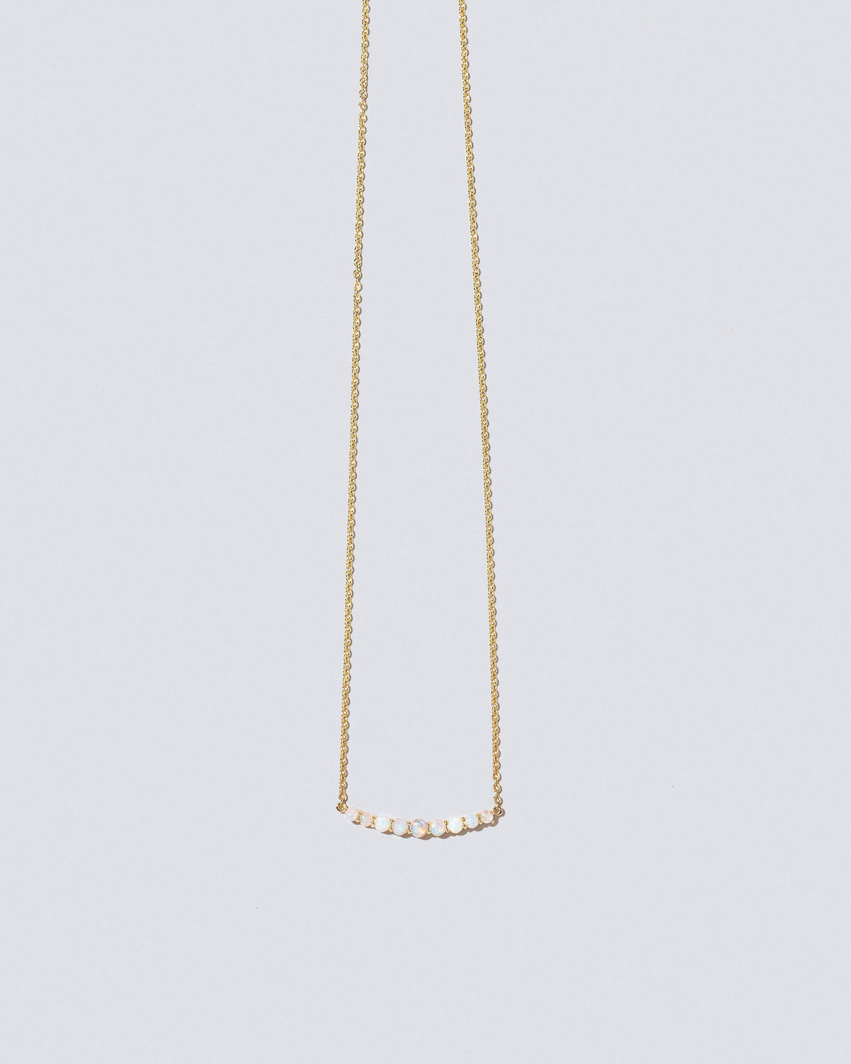 Opal Crescent Necklace on light color background.
