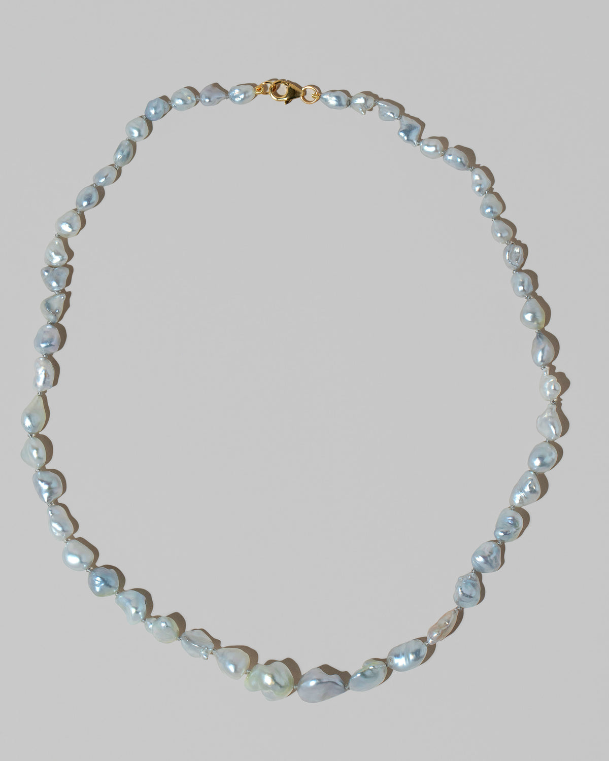 Closeup details of the Ula Pearl Necklace 001 on light color background.