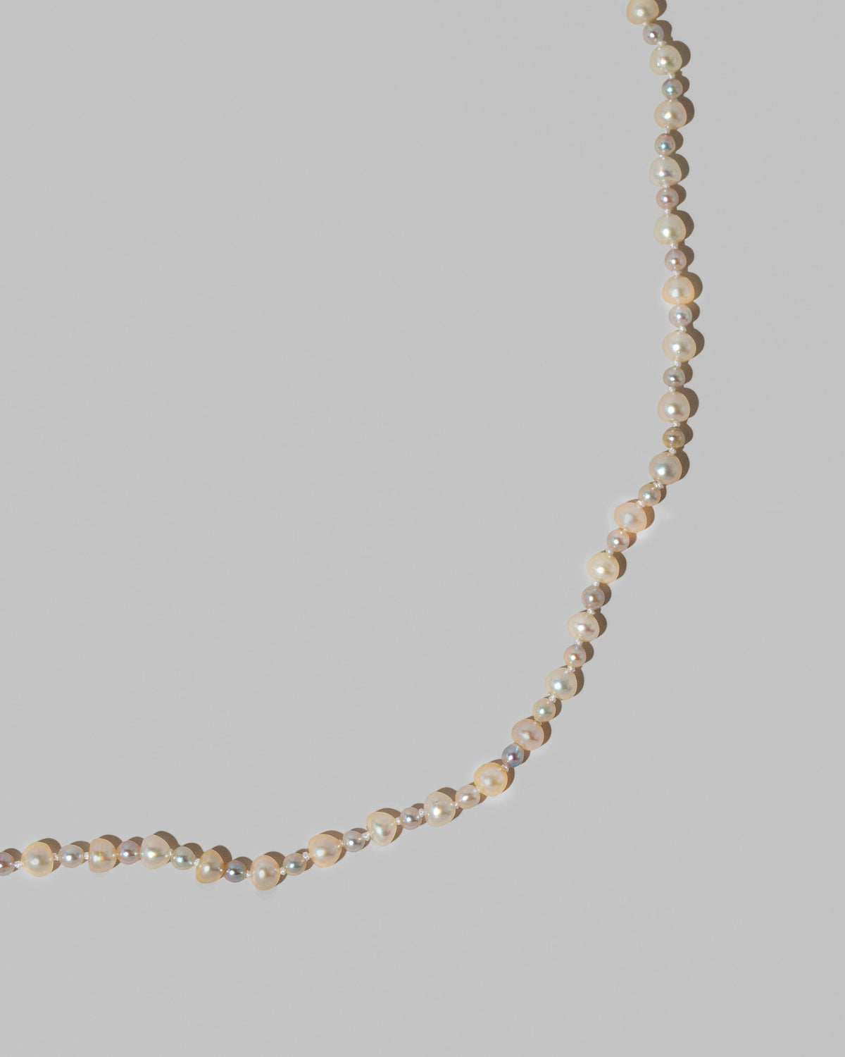 Closeup details of the Ula Pearl Necklace 004 on light color background.