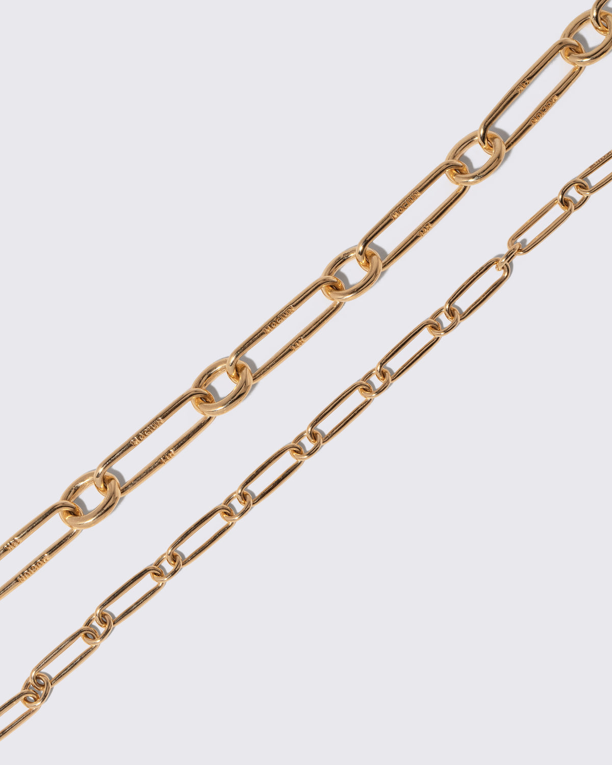 Closeup details of the Gold Link Necklace and Petite Link Necklace on light color background.