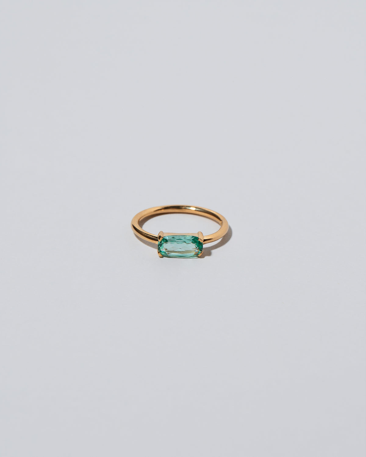 Green Adage Ring on light color background.