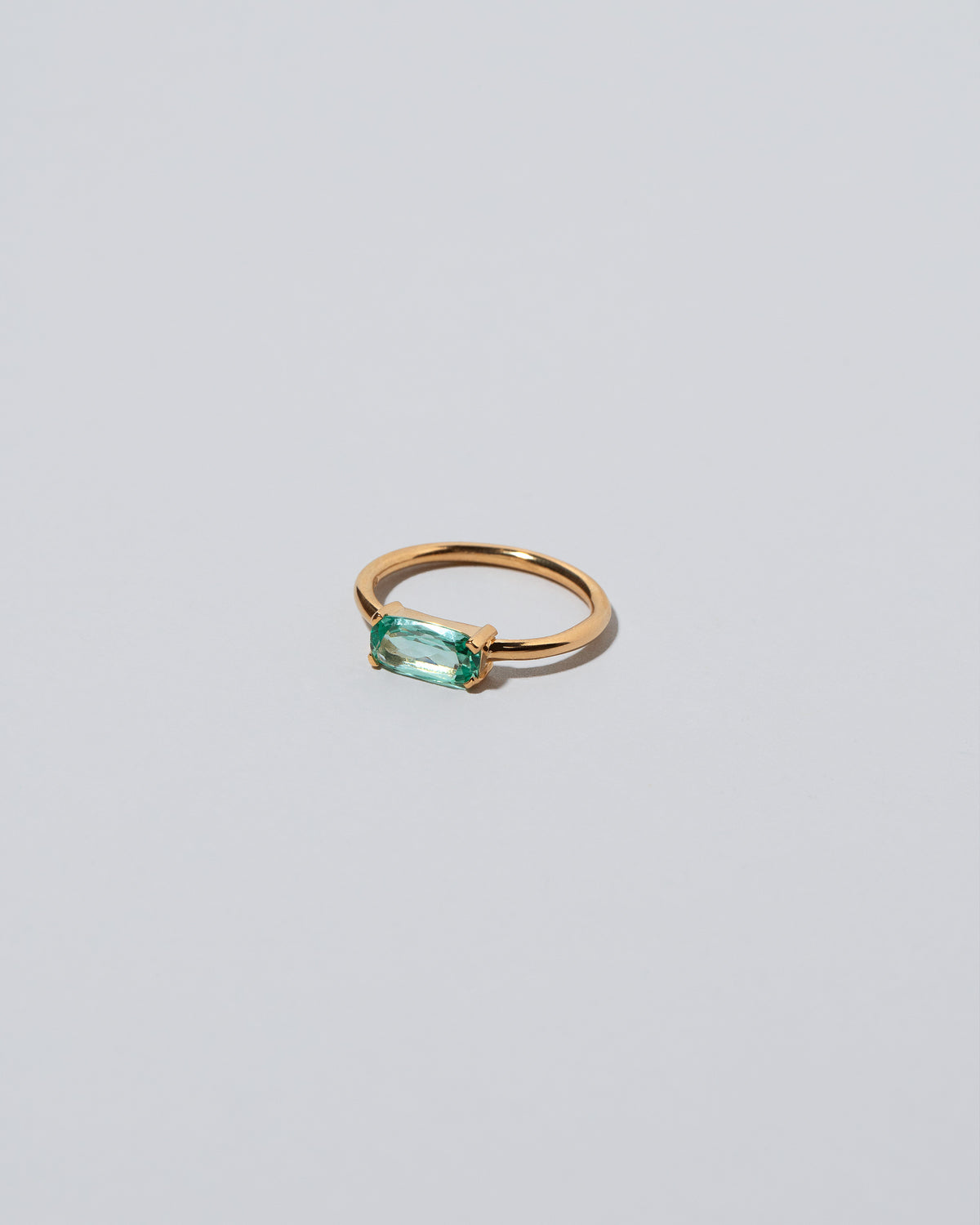 View from the side of the Green Adage Ring on light color background.