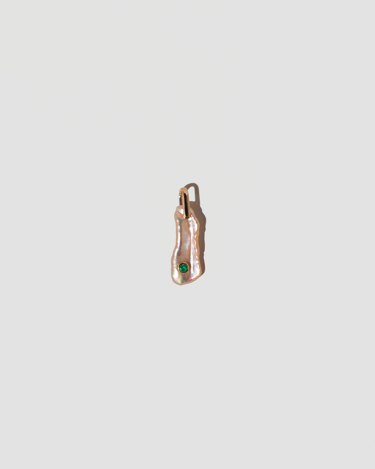 May Birthstone Pearl Pendant With Emerald on light color background.