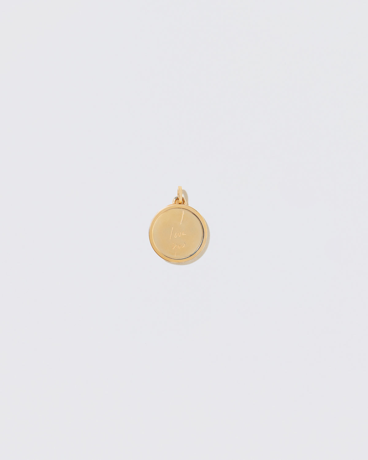 View from the back of a finished Small Round Pendant Memento Pendant engraved with 'I Love You' on light color background.