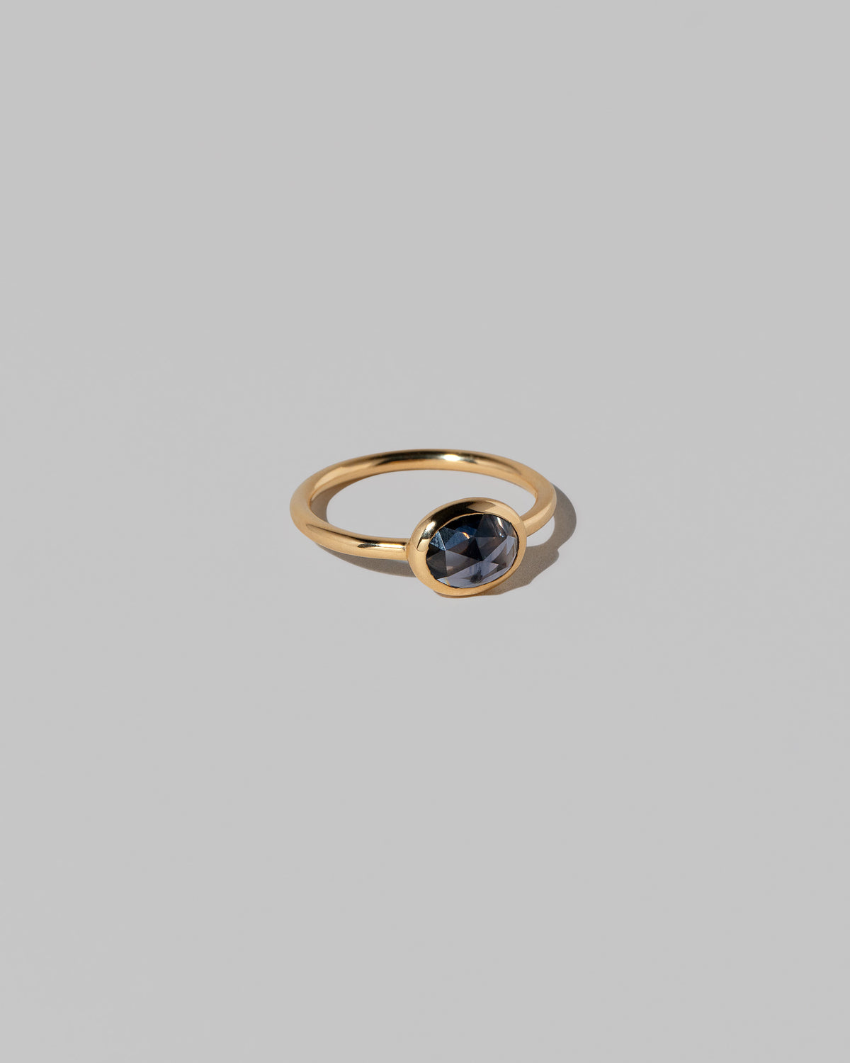 View from the side of the Gusher Blue Sapphire Ring 022 on light color background.
