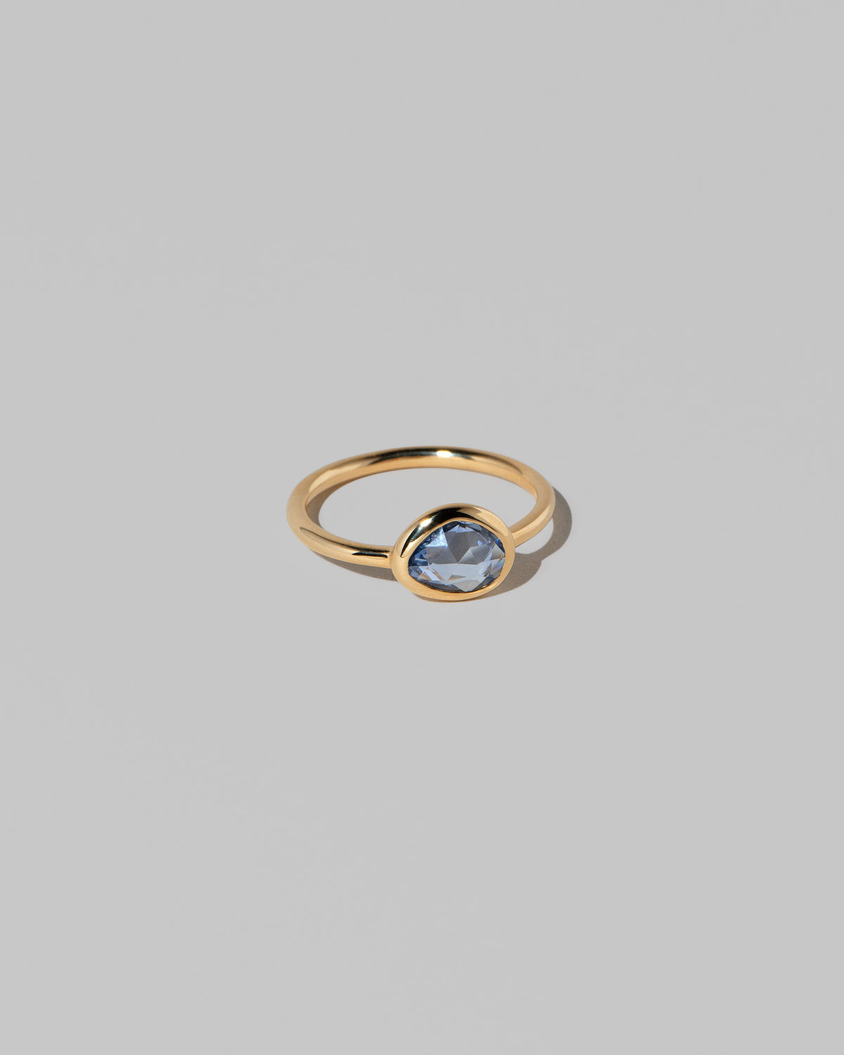 View from the side of the Gusher Blue Sapphire Ring 023 on light color background.