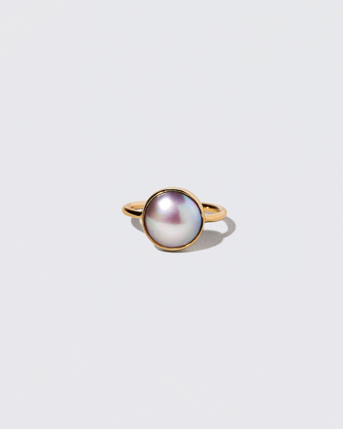 Gold Albert Ring on light color background.